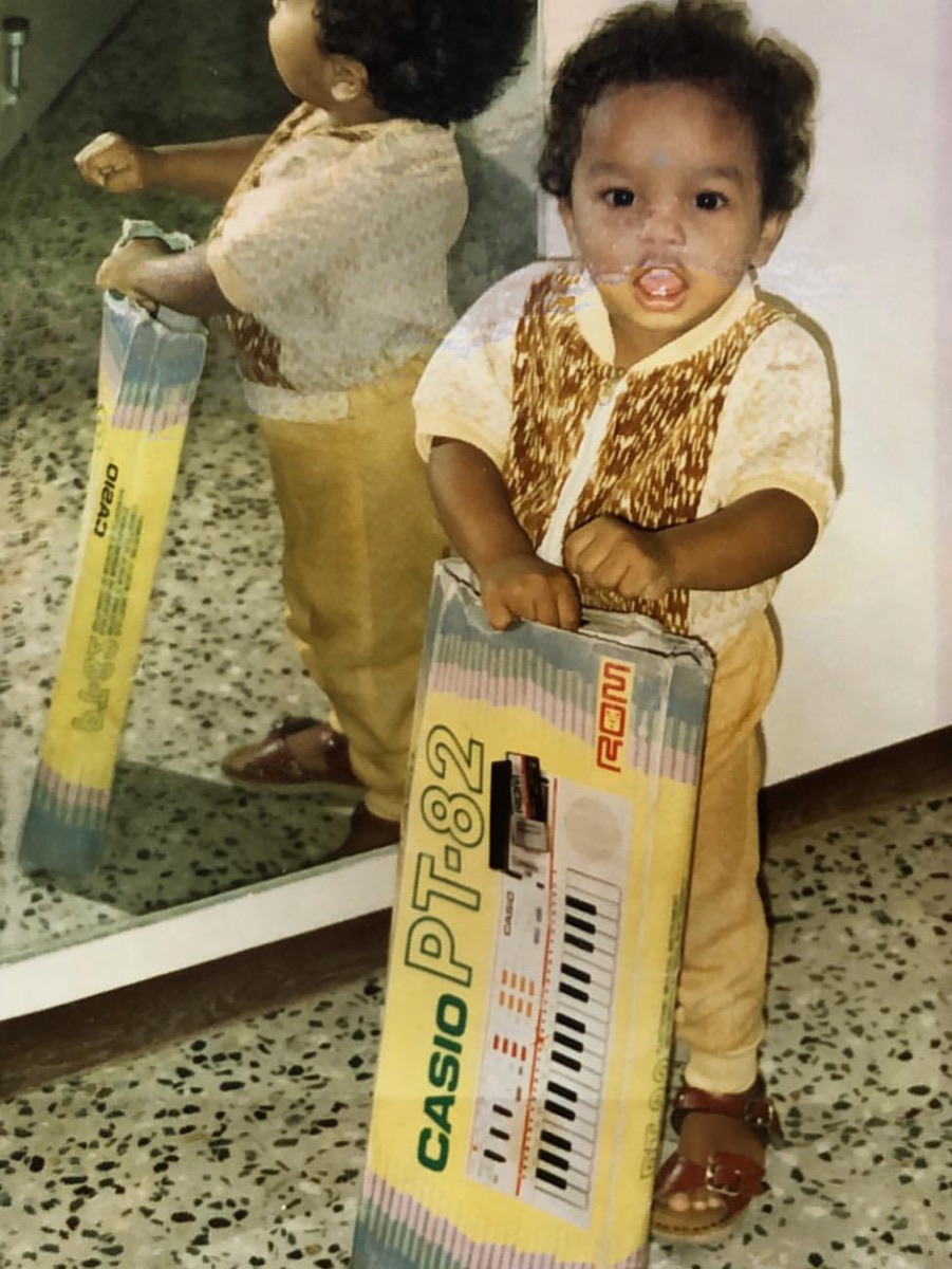 A young boy holding a boxed Casio PT-82 keyboard